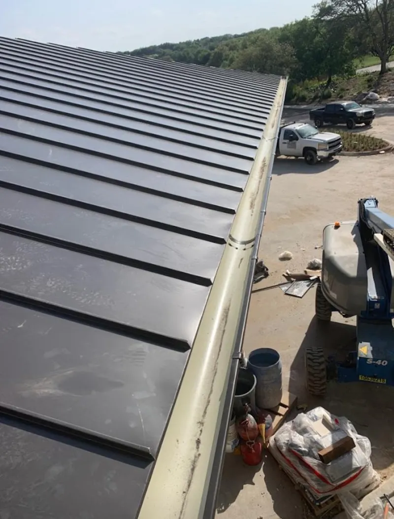 Standing seam panel and gutter detail on a metal roofing jobsite in Muskegon